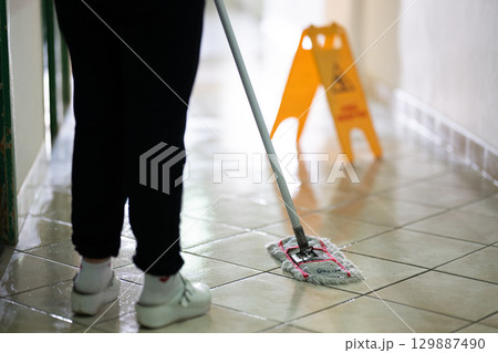 Cleaning Staff in Hospital Hallway.Female janitor standing in a hospital corridor with mop and bucket, symbolizing cleanliness and hygiene. Cleaning Staff in Hospital Hallway.Female janitor standing in a hospital corridor with mop and bucket, symbolizing cleanliness and hygiene. 129887490