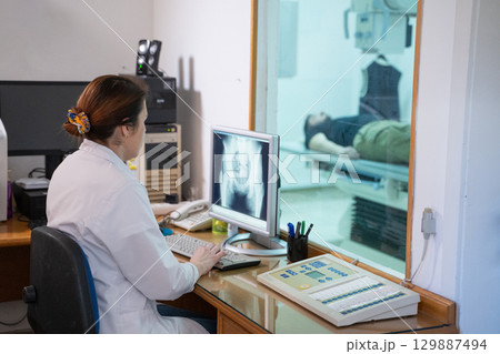 Radiologist Analyzing X-Ray Scans in a Medical Imaging Room. 129887494