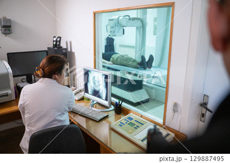 Radiologist Analyzing X-Ray Scans in a Medical Imaging Room. Radiologist Analyzing X-Ray Scans in a Medical Imaging Room. 129887495