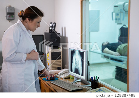 Radiologist Analyzing X Ray Scans in a Medical Imaging Room. 129887499
