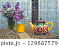 Bouquet of wild flowers with pink anemones and yellow teapot 129887579