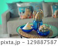 Marine style in the apartment interior - a sofa with pillows and a table with shells and fish figures. 129887587