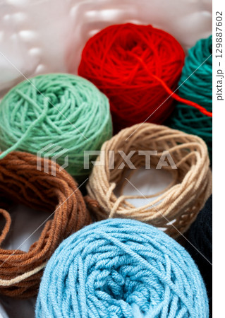 Colorful yarn balls in basket for knitting and crochet projects 129887602