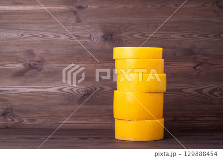Stack of wax discs on wooden background. Making new honeycomb foundation wax frames for bee hives of used wax 129888454