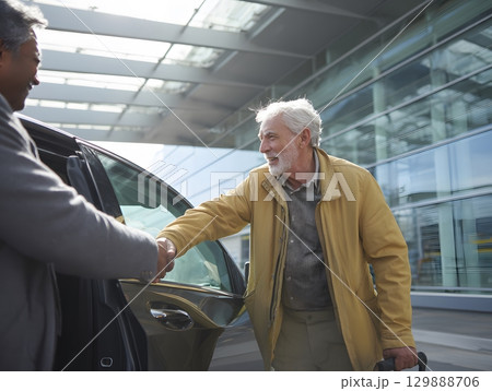 man helping elderly relative into car outside terminal 129888706