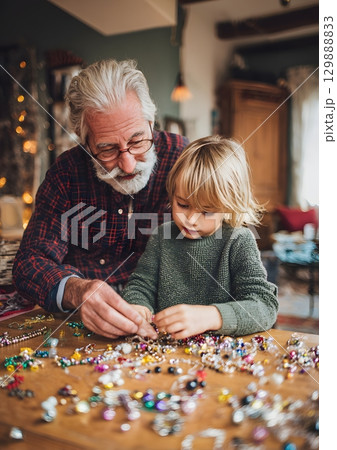 child and grandparent making ornaments together 129888833