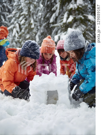 group of kids building snow fort 129889167