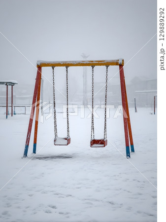 swing set in snow covered playground 129889292