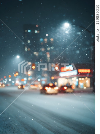 blurry snowstorm night with glowing city lights 129889319