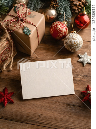 Christmas card mockup on wooden table with holiday ornaments 129889532