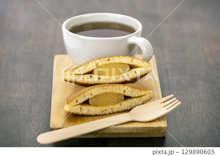 Tea pancake wooden fork dessert sweet snack breakfast hot drink brown cup wooden board filling baked pastry cozy inviting delicious treat homemade afternoon break comfort warm beverage plate 129890603