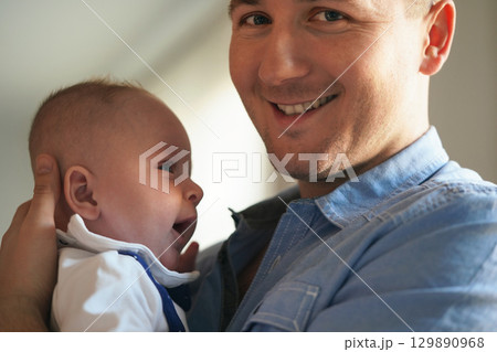 Young man holding his baby son on arms, closeup detail 129890968