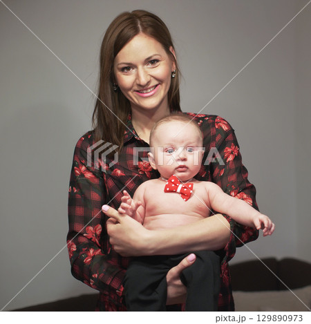 Young mother posing with her baby son, holding him on hands Young mother posing with her baby son, holding him on hands 129890973