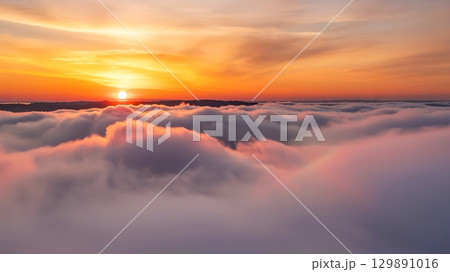 view of the sunrise over a sea of clouds with a colorful sky above it 129891016
