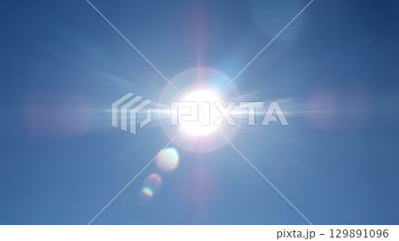 Bright sunlight with radiant starburst effect and glowing lens flares across vibrant daylight sky symbolizing hope 129891096