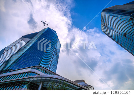 日本の東京都市景観 航空機通過…猛烈な暑さ、発達した雲が高輪ゲートウェイシティ上空に…＝8月21日 129891164
