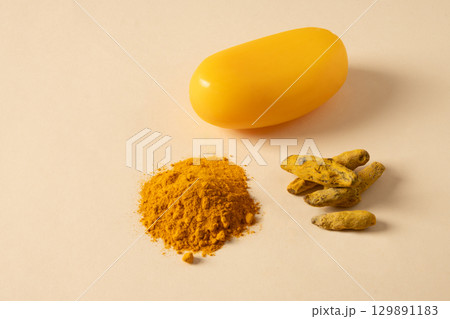 Handmade turmeric soap bars, powder and turmeric root on yellow background. Organic skincare product perfect for wellness, beauty, and organic body care concepts. Close up. Copy space 129891183