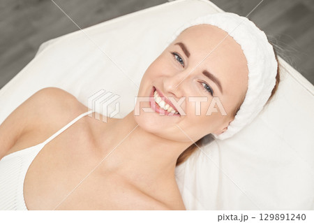 Smiling caucasian female adult relaxing during skincare treatment in spa Smiling caucasian female adult relaxing during skincare treatment in spa 129891240