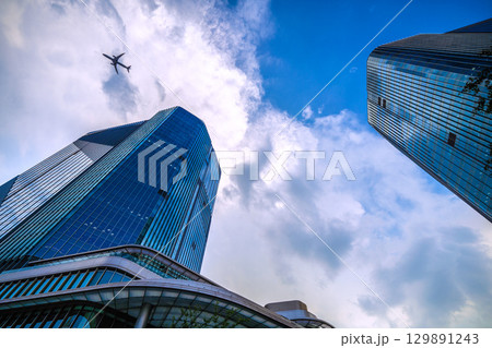 日本の東京都市景観 航空機通過…猛烈な暑さ、発達した雲が高輪ゲートウェイシティ上空に…＝8月21日 129891243