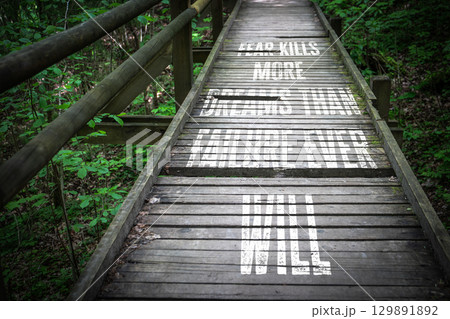 Inspirational Quote on Wooden Bridge in Forest Encouraging Courage Over Fear and Failure 129891892