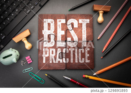 Best Practice Concept Displayed on Puzzle Pieces Surrounded by Office Supplies and Workspace Tools 129891893