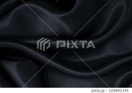 Smooth elegant black silk or satin luxury cloth texture as abstract background. Luxurious background design 129892145