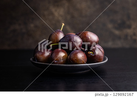 Ripe plums on black table. Ripe plums on black table. 129892167