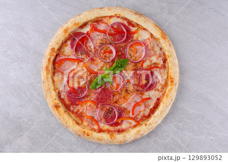 Spicy pizza topped with jalapenos, pepperoni, corn, red peppers, crispy onions, and drizzled with barbecue sauce 129893052