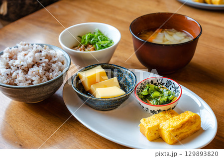 雑穀ご飯や味噌汁、卵焼きと小鉢が並ぶ和風の朝食セット 雑穀ご飯や味噌汁、卵焼きと小鉢が並ぶ和風の朝食セット 129893820