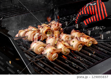 Grilled pork belly skewers cooking on barbecue grill Grilled pork belly skewers cooking on barbecue grill 129893837