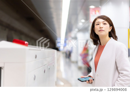 ホームでスマホを使う女性 129894008