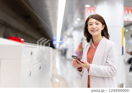 ホームでスマホを使う女性 129894009