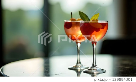 Two colorful cocktails with garnishes served in elegant glasses on a table 129894301