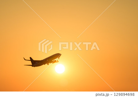 美しい夕日を背景に飛行機風景(コピースペース素材) 美しい夕日を背景に飛行機風景(コピースペース素材) 129894698