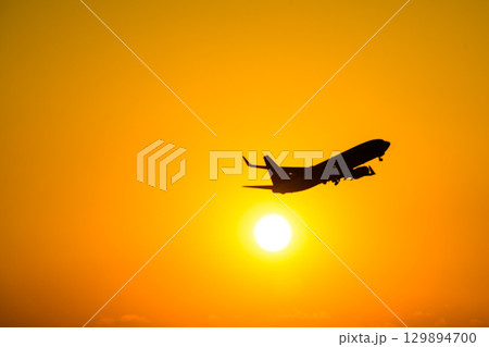 美しい夕日を背景に飛行機風景(コピースペース素材) 129894700