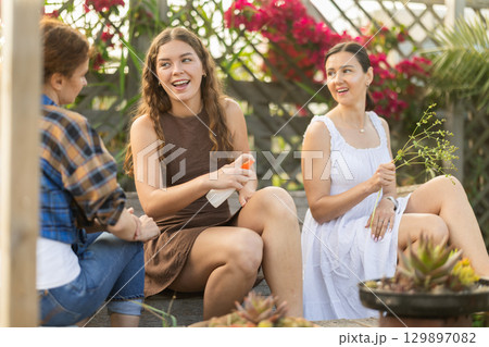 Women spray mosquito repellent on their legs and arms while working in farm and garden Women spray mosquito repellent on their legs and arms while working in farm and garden 129897082