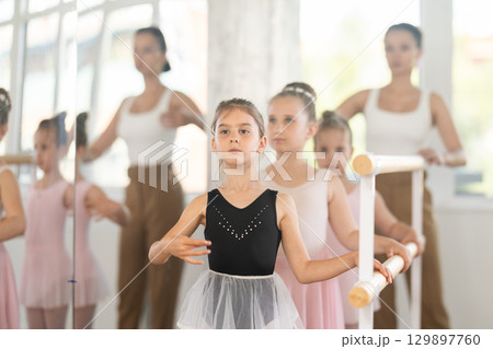 Lesson for little ballerinas - girls learn to dance ballet in choreographic class 129897760