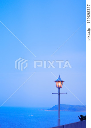 4月夕方17時頃の海と電灯と山影 129898327