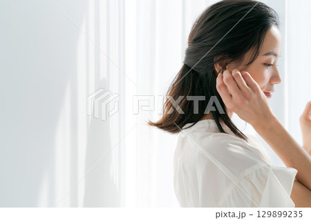 窓辺に立つ30代女性のポートレート 129899235