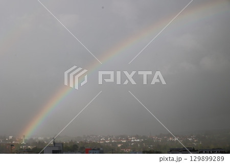 A rainbow is seen in the sky above a city 129899289