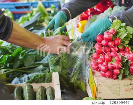 Man is buying vegetables from a market 129899445