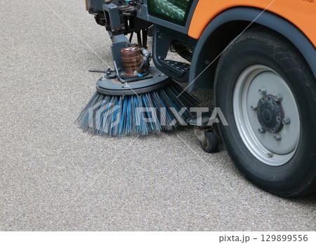 Street sweeper is cleaning the street with a blue brush Street sweeper is cleaning the street with a blue brush 129899556