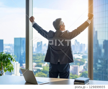 窓辺でリラックスするシニアビジネスマン 窓辺でリラックスするシニアビジネスマン 129899935