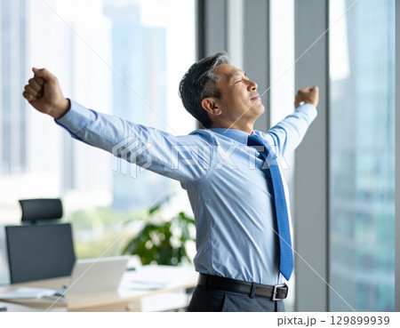 窓辺でリラックスするシニアビジネスマン 129899939