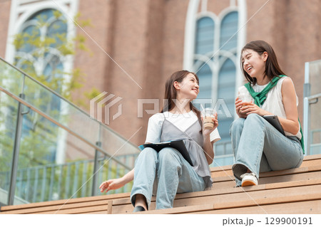 大学のオープンカフェで会話をする女子大生 大学のオープンカフェで会話をする女子大生 129900191