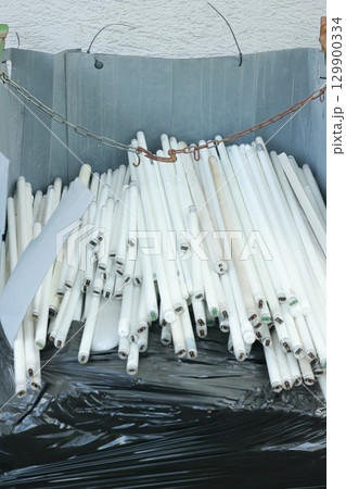 Pile of white light bulbs are in a trash can Pile of white light bulbs are in a trash can 129900334