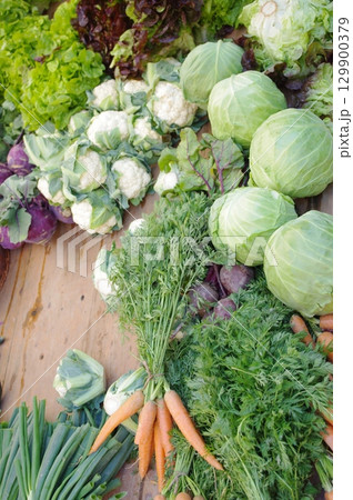 Table full of vegetables including carrots, cabbage, and lettuce 129900379