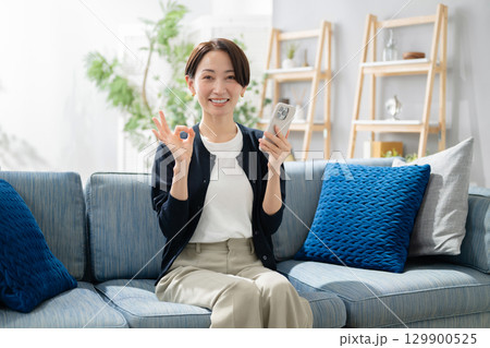 スマホを持ってOKサインをする女性 スマホを持ってOKサインをする女性 129900525
