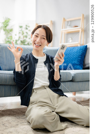 スマホを持ってOKサインをする女性 スマホを持ってOKサインをする女性 129900526