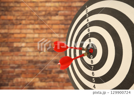 Red darts strike a target with great accuracy demonstrating skill 129900724